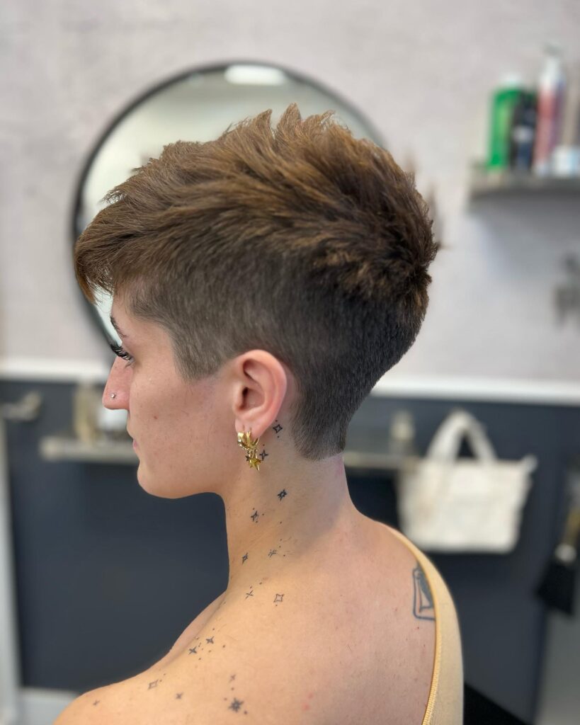 Short textured tomboy pixie with tapered sides and a fuller tousled brown top