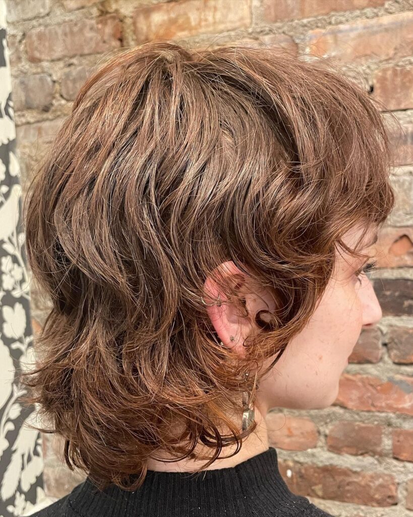 Medium length tomboy shag with tousled layers and warm brown texture