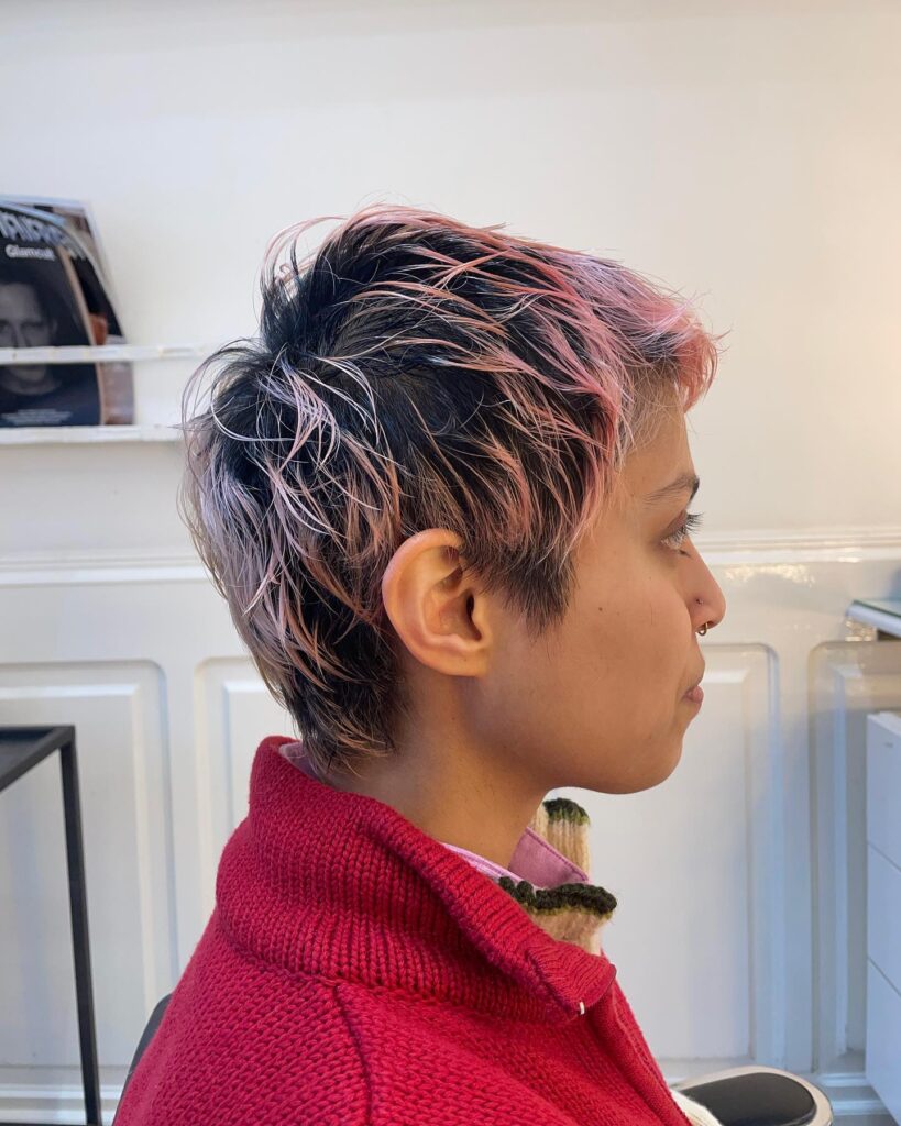 Short layered tomboy haircut with dark roots and soft pink highlighted texture