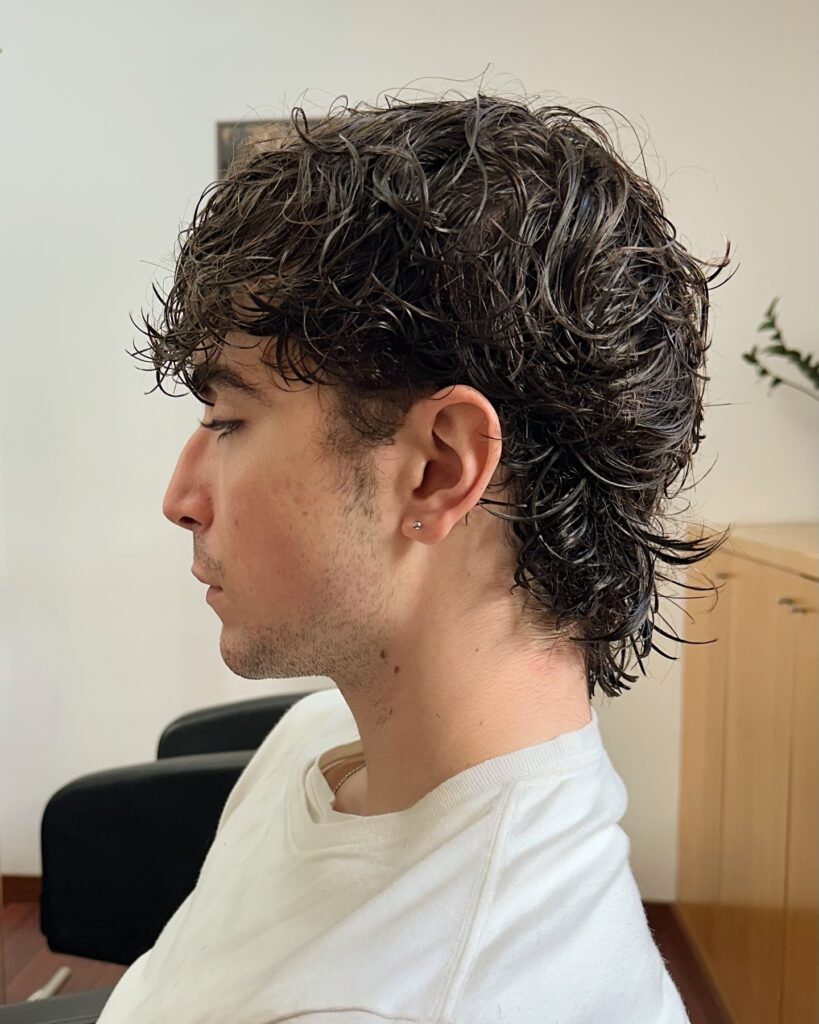 Medium length tomboy shag haircut with natural curls and layered texture