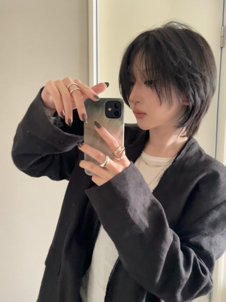 A woman with a short layered shag bob in warm blonde tones with textured ends and natural movement.