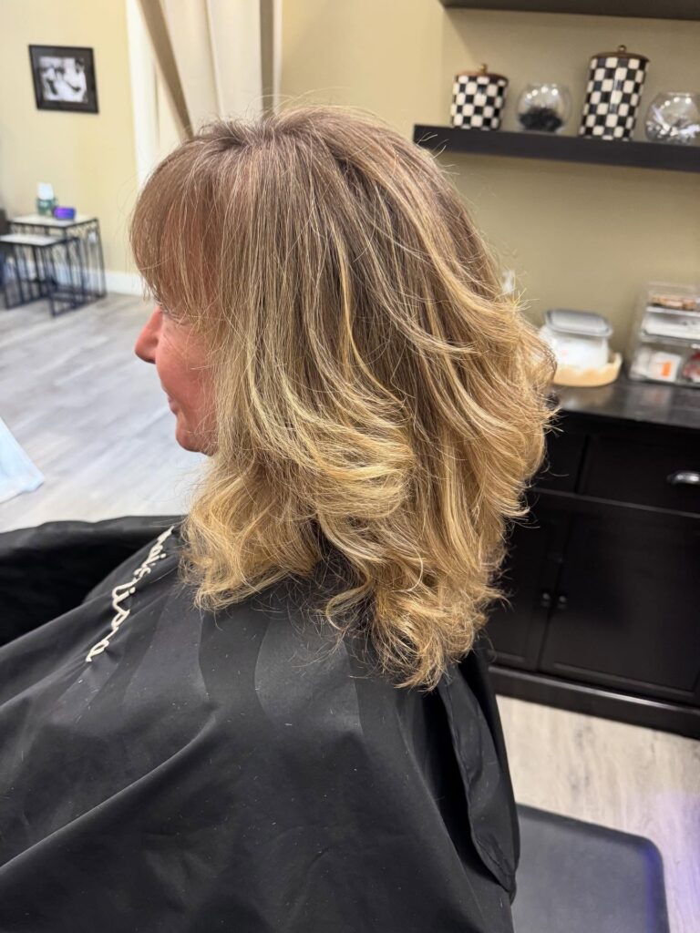 A glossy blonde lob with soft waves and a full rounded fringe.