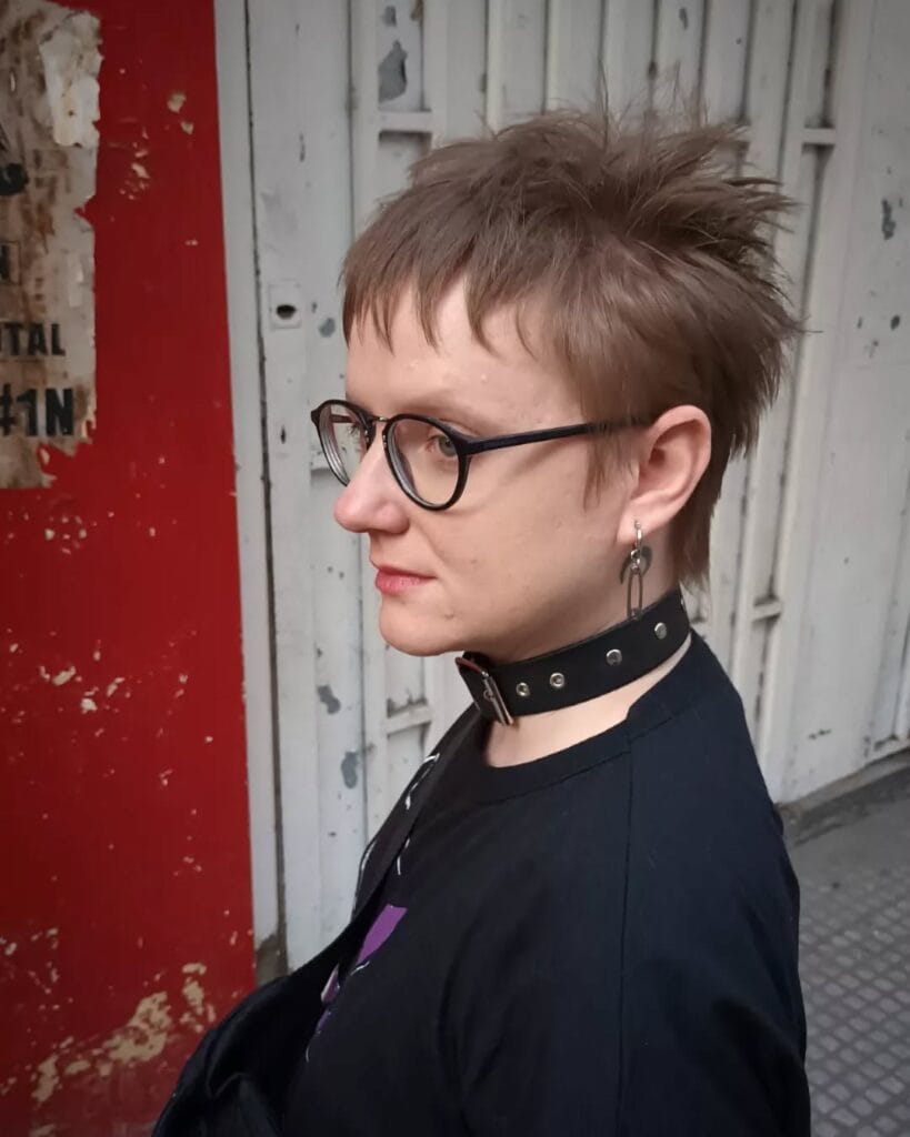Short choppy tomboy crop with micro fringe and textured messy layers in light brown hair.
