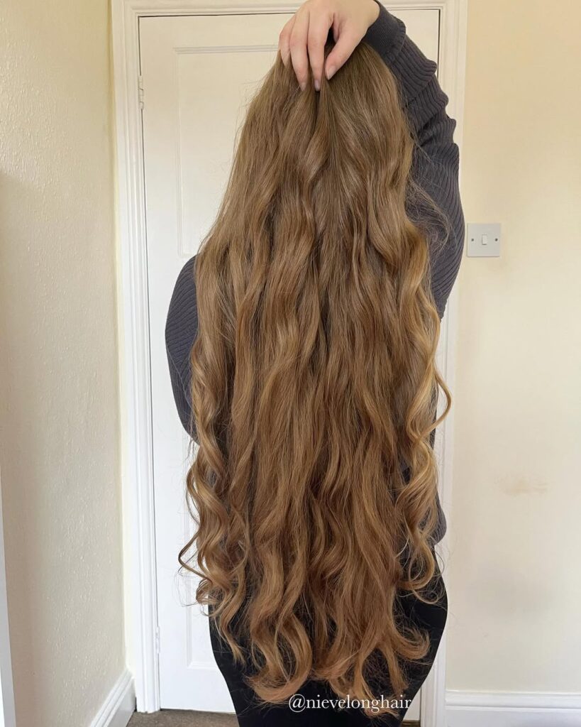 Extra long light brown hair with soft natural waves cascading down the back.