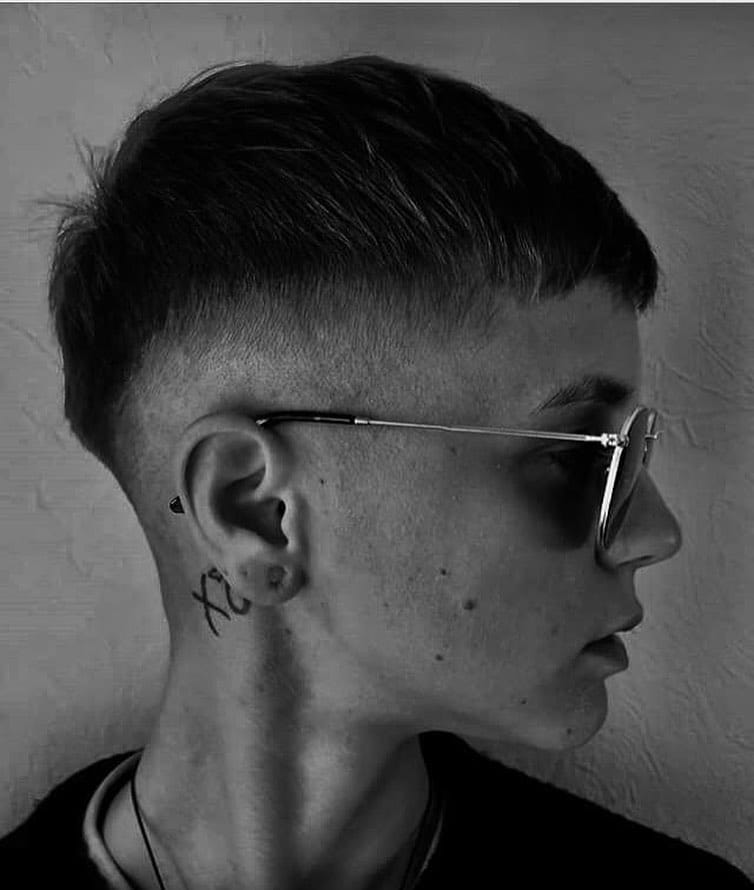 Short tomboy crop haircut with a soft fade on the sides and a clean textured top in dark hair.