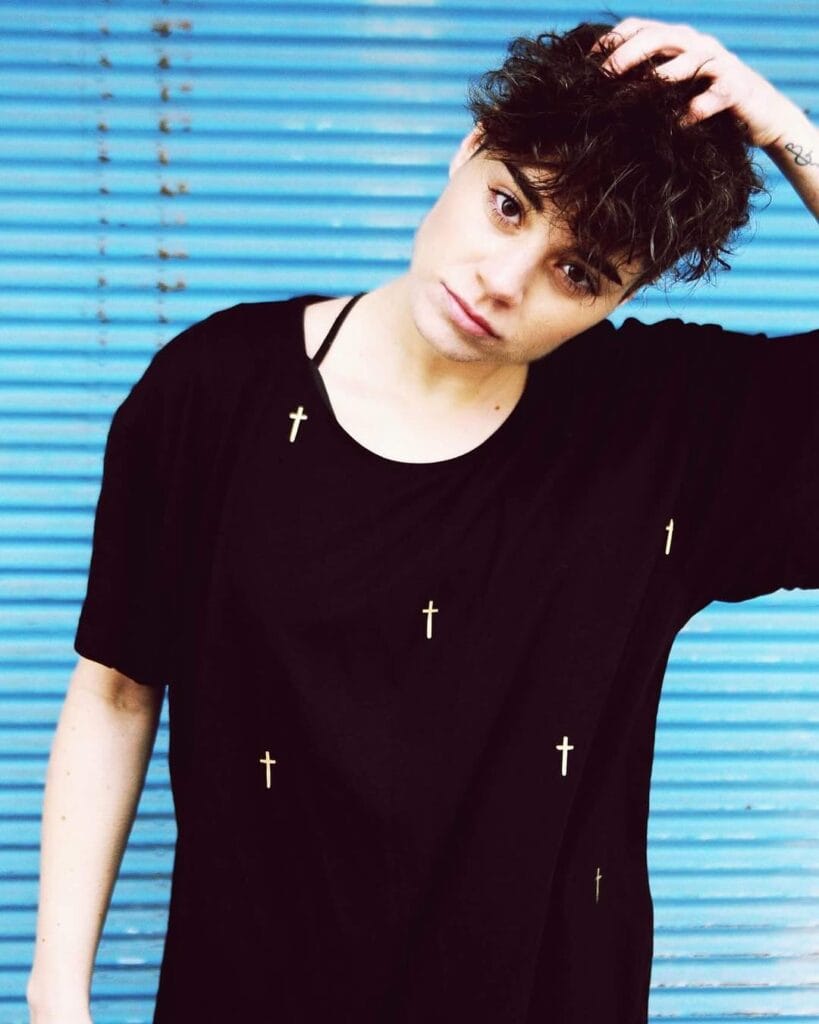 Short tomboy curly crop with soft messy texture and natural volume in dark brown hair.