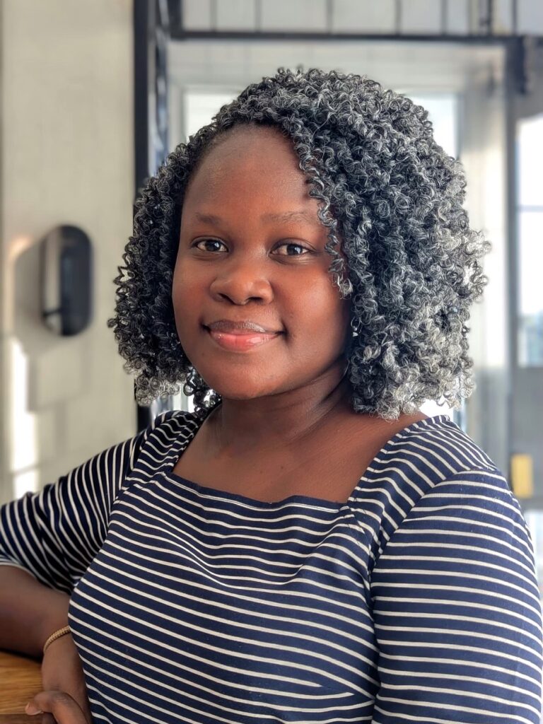 A woman with a short natural curly bob featuring tight coils and soft volume.