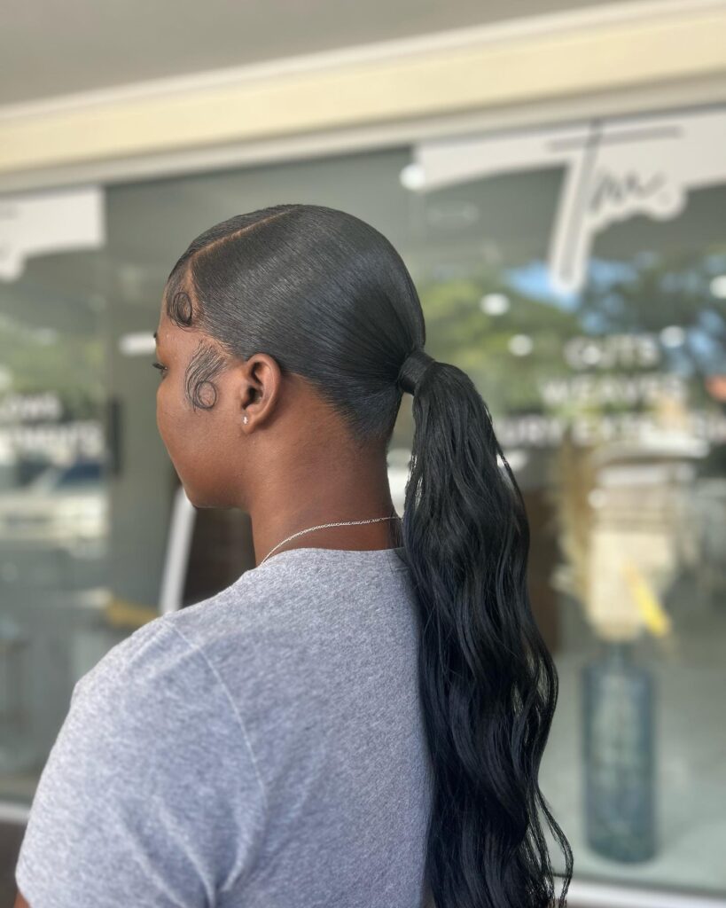 Ultra sleek low ponytail with smooth roots and a wrapped base detail.