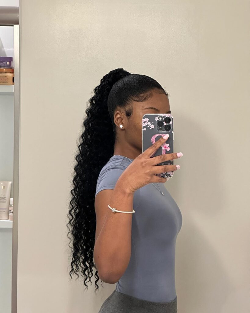 Sleek high ponytail with laid edges and a long wavy textured tail.