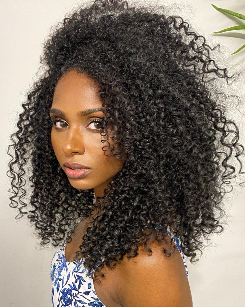 Long natural curly hair with full volume and soft textured definition.