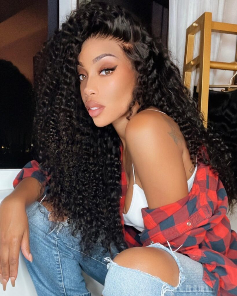 Long black curly hair with a deep side part and defined glossy curls.