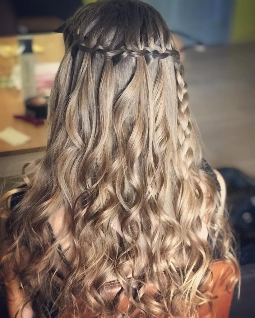 Halo braid with long textured wavy hair and a small accent braid on the side.