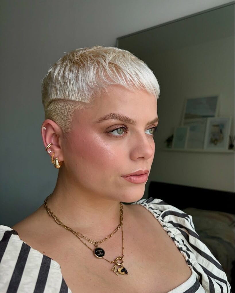 A short shaggy tomboy haircut with wispy fringe and layered brunette texture.