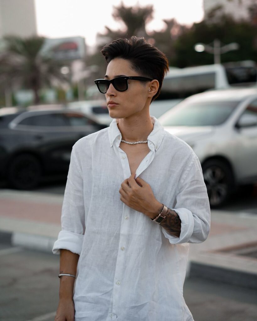A woman with a textured tomboy undercut featuring short sides and a voluminous slicked back top.