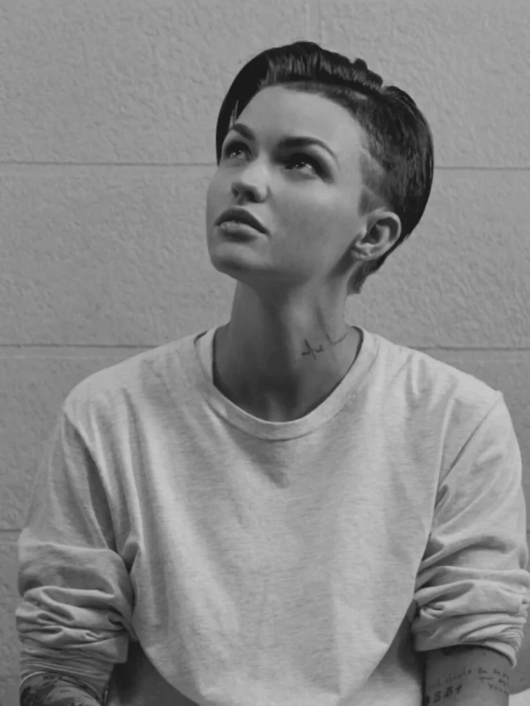 A woman with a sleek tomboy undercut hairstyle featuring shaved sides and a longer textured top brushed back.