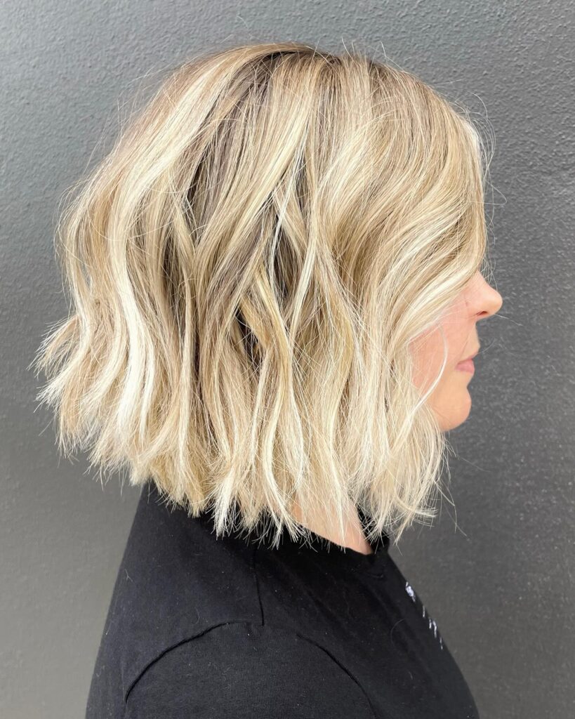 A wavy blonde textured bob with layered ends and soft dimension.