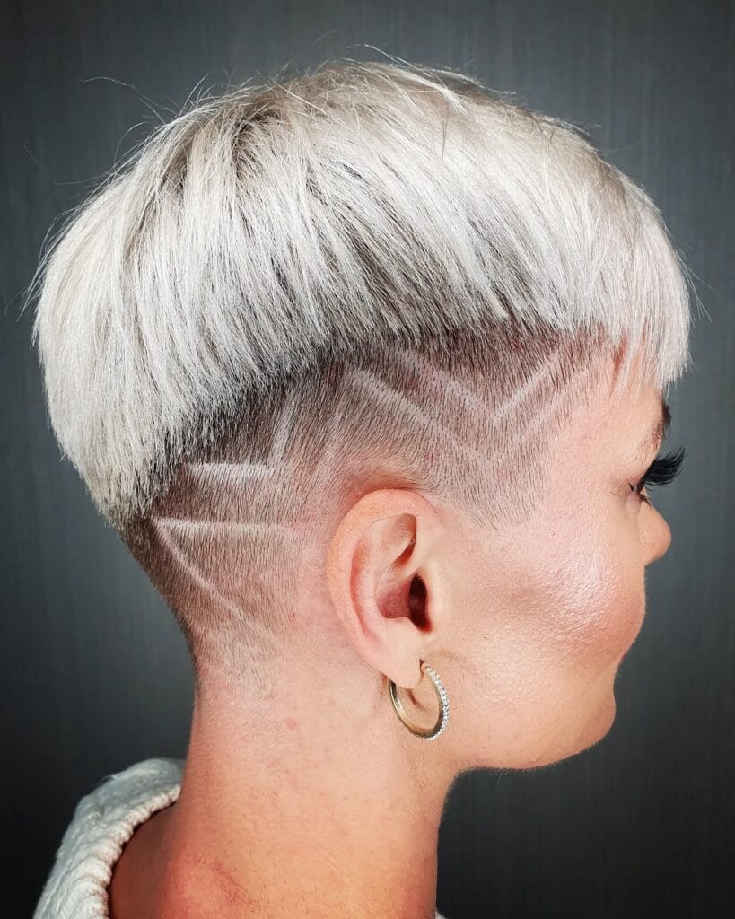 A short platinum blonde tomboy crop with a shaved undercut and clean line design on the sides.