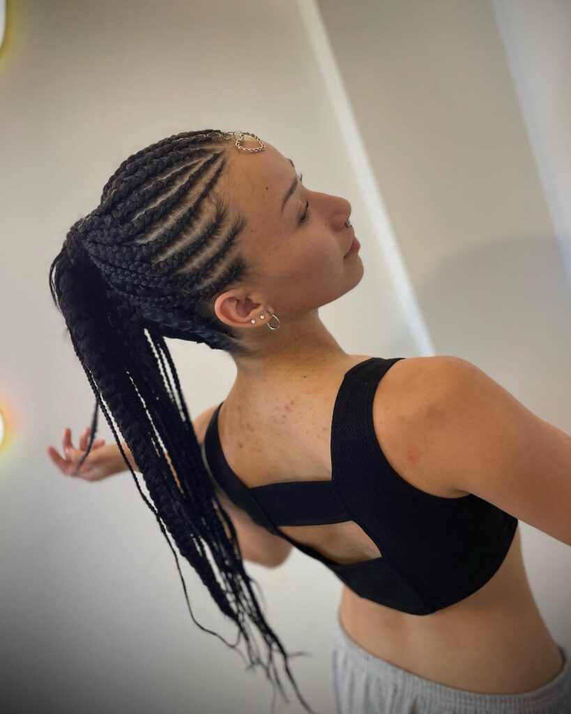 High ponytail made from tight cornrows with long braids flowing down the back.