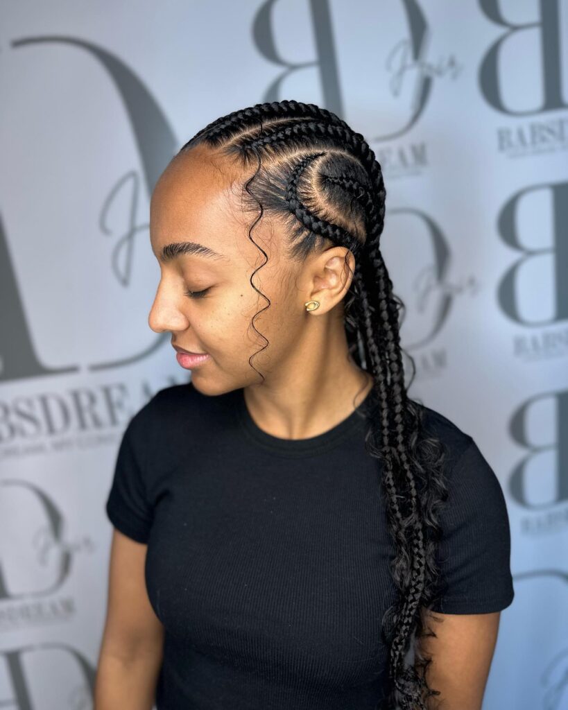 Side-swept cornrows with neat parts and long curly ends cascading over one shoulder.