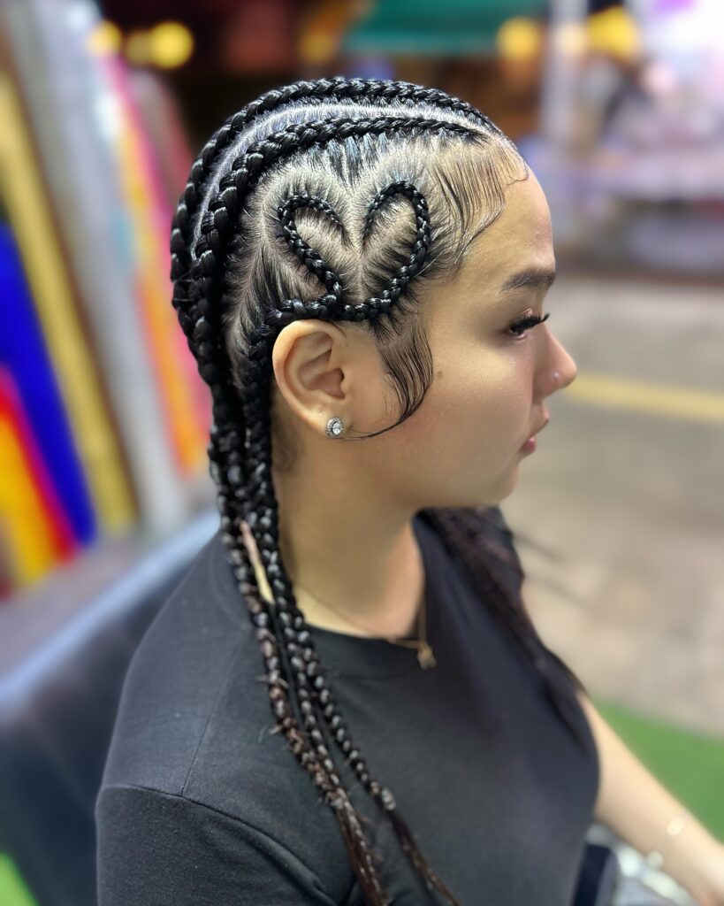 Cornrows styled into a heart shape with long sleek braids flowing down.