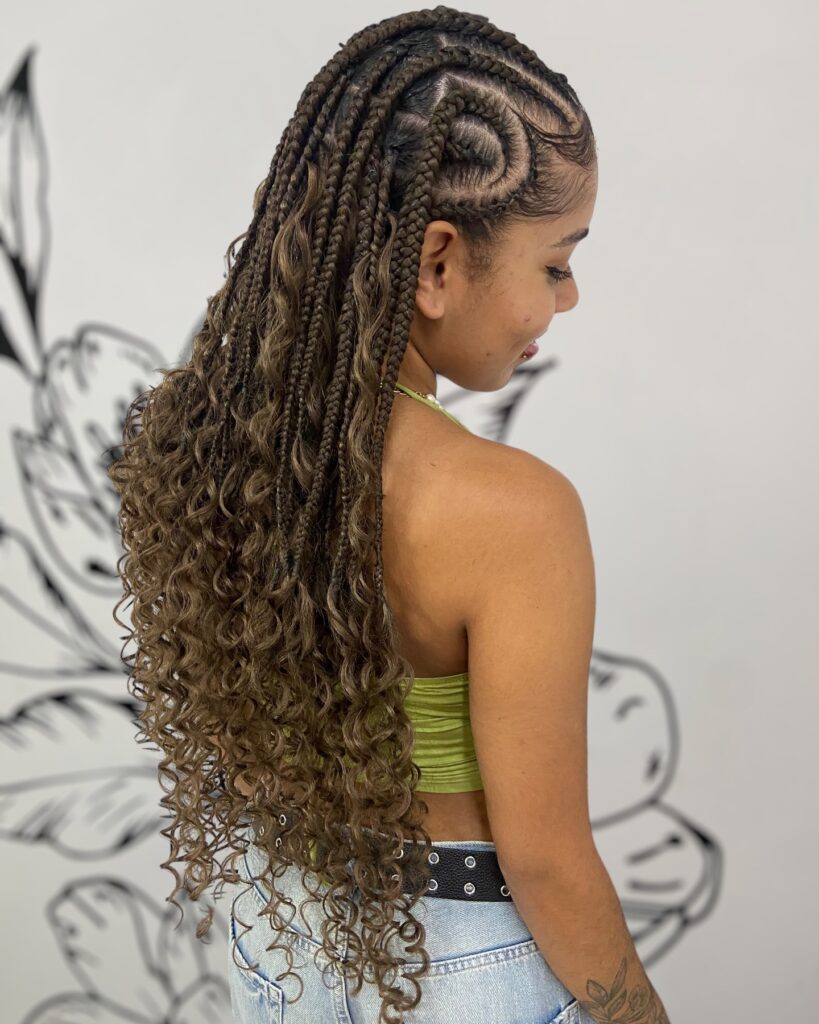 Cornrow braids at the top blending into long curly hair cascading down the back.