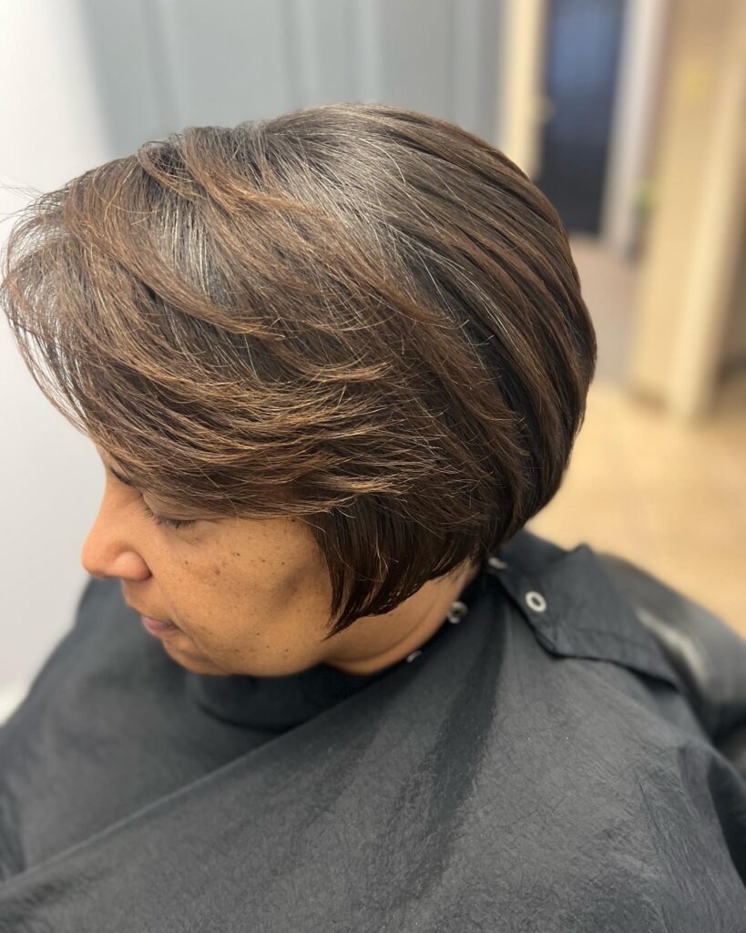 Short brown bob with feathered layers and soft volume at the crown.