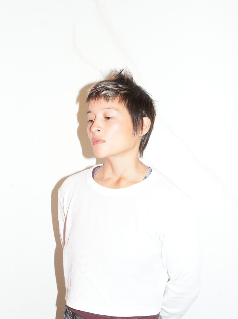 Short tomboy shag haircut with choppy layers, soft fringe, and slightly longer back.