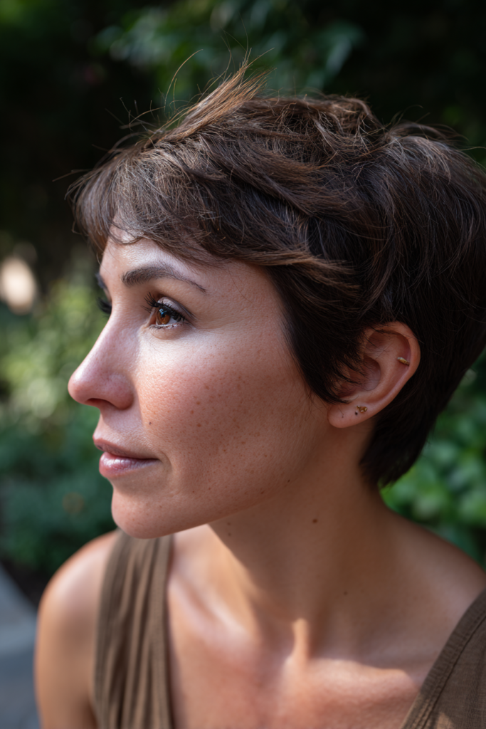A woman with a short textured brunette pixie cut swept to the side.