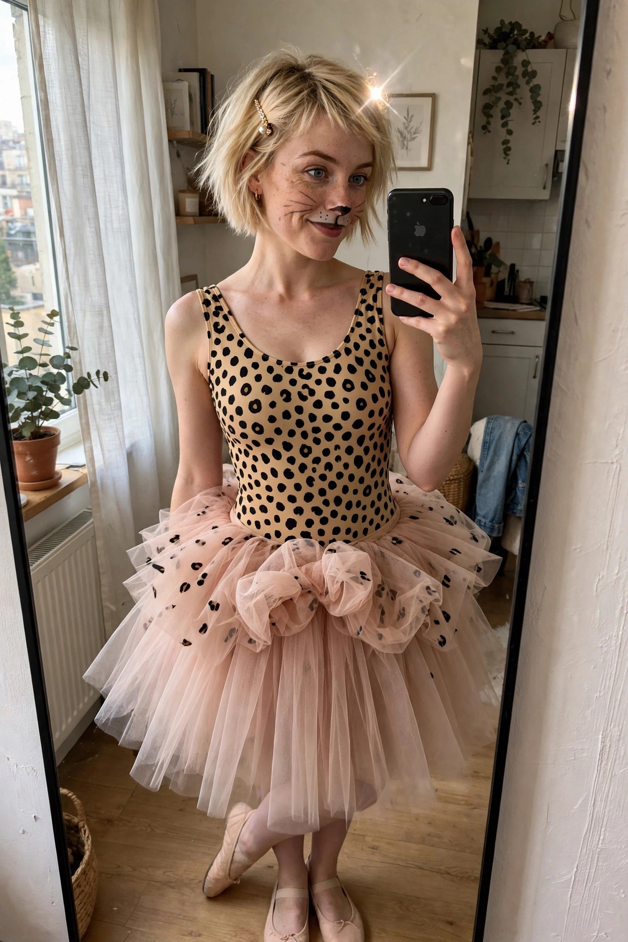 Woman wearing a tan leotard with black spots, layered under a pink tulle tutu also printed with spots, plus cat face paint and ballet flats.