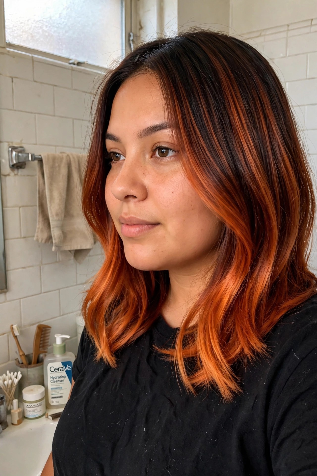 Woman with dark brown hair featuring bold orange red highlights throughout the lengths and ends in a shoulder length wavy style.